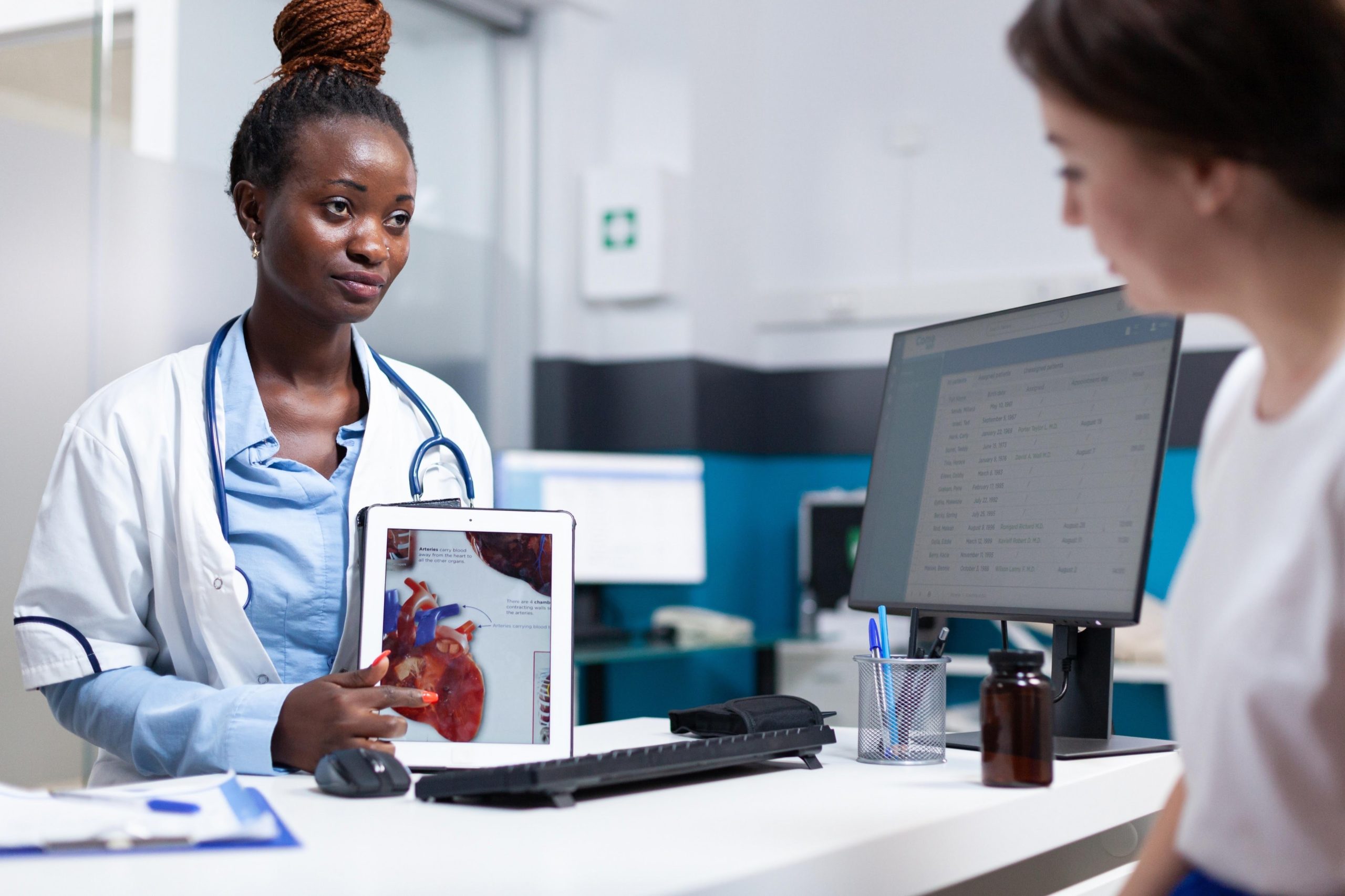 醫師與患者進行一對一諮詢，使用解剖模型解釋不同手術方式對肛門組織的影響。